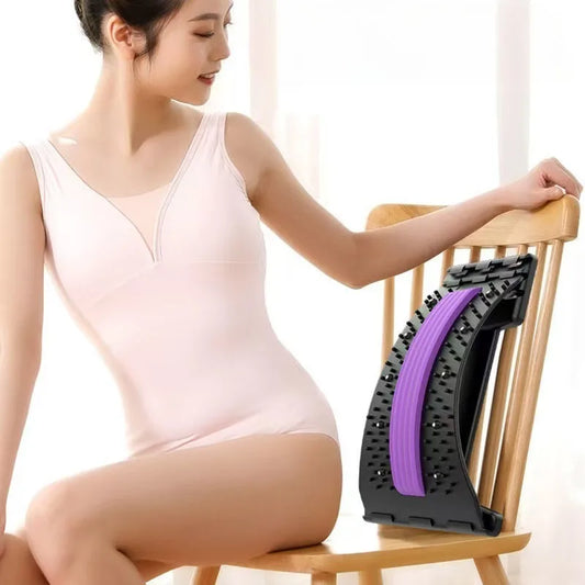 BackBalance back stretcher for pain relief in black and purple placed on wooden chair next to woman