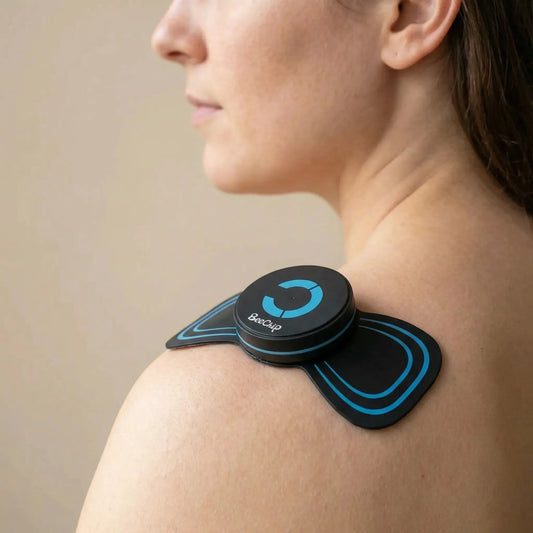 BackBalance mini body massager for pain relief placed on a woman’s shoulder for muscle relaxation